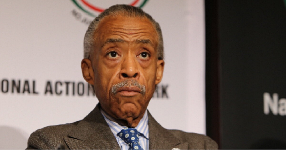 Al Sharpton with a National Action Network backdrop behind him.