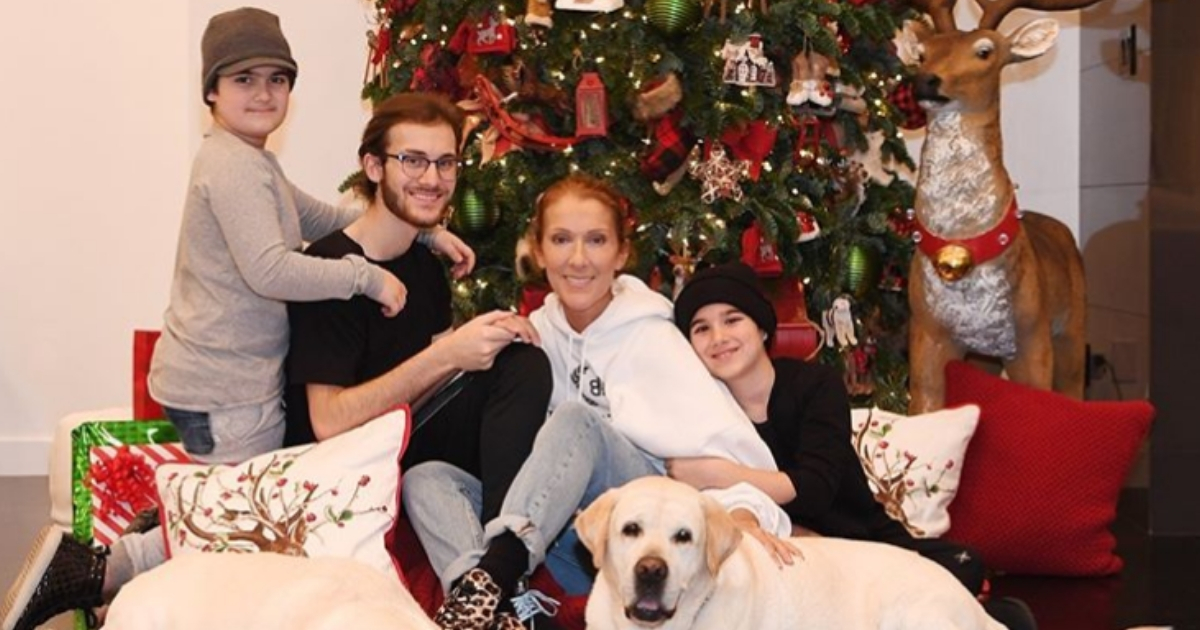 Céline Dion and her three children in front of a Christmas tree.