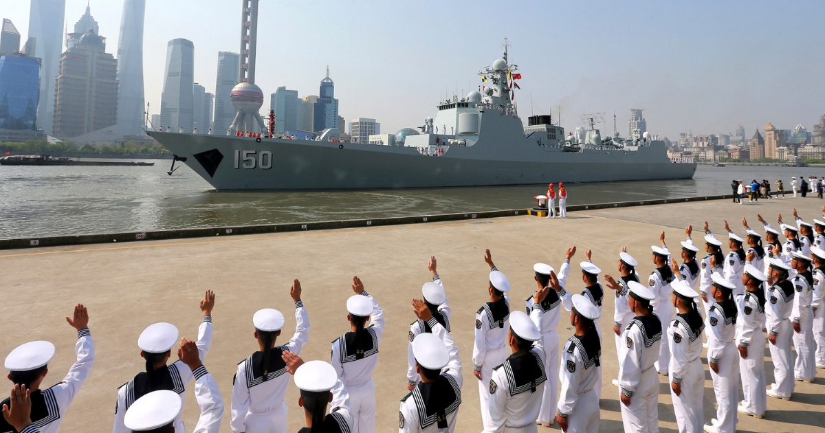 Chinese sailors wave off a Chinese naval ship as it leaves Shanghai.