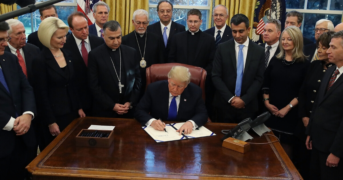 President Donald Trump signs H.R. 390, the 'Iraq and Syria Genocide Relief and Accountability Act of 2018' in the Oval Office at the White House on Dec. 11, 2018, in Washington, D.C.