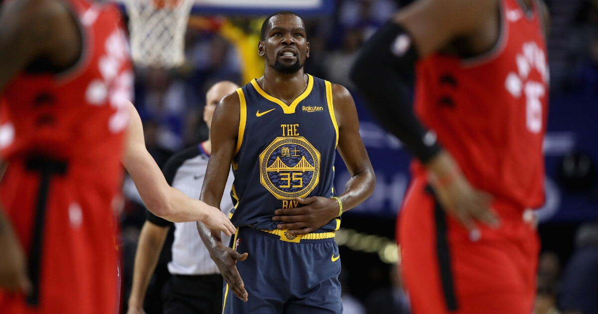 Kevin Durant of the Golden State Warriors grimaces after he was kicked in the stomach as he drew an offensive foul during Wednesday night's game against the Toronto Raptors at ORACLE Arena.