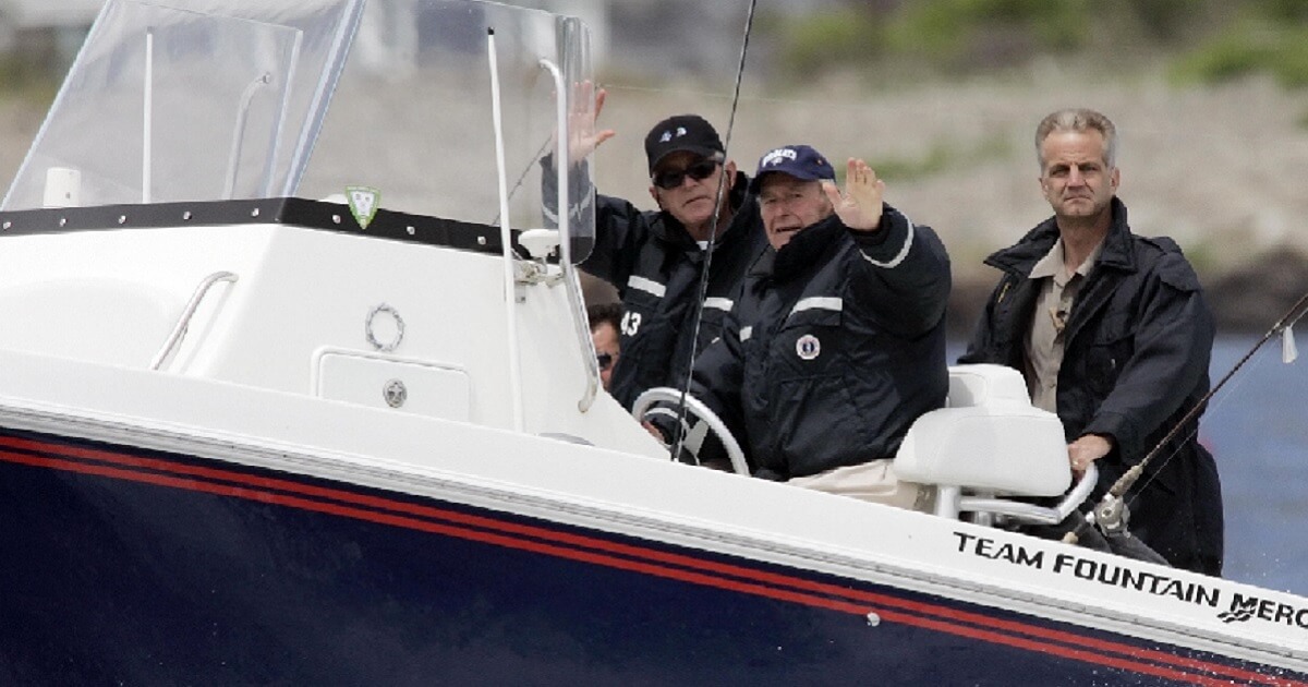 George W. Bush and George H.W. Bush in a speedboat with a Secret Service agent.
