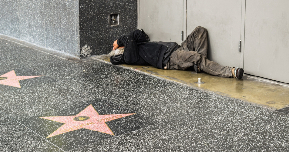 A homeless man sleeps along the Hollywood Walk of Fame in California.