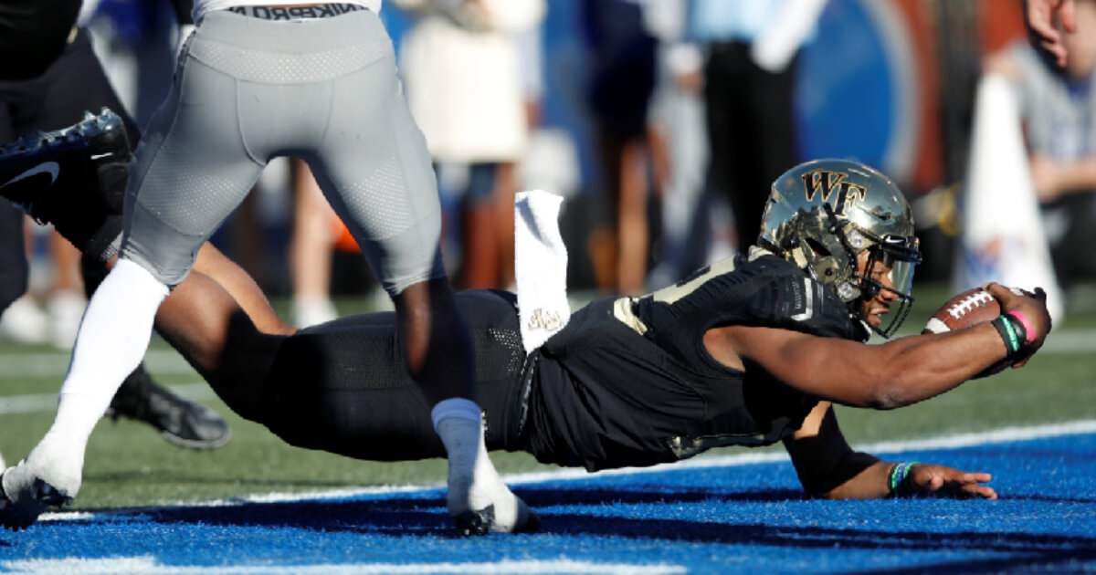 Jamie Newman #12 of the Wake Forest Demon Deacons dives into the end zone for the winning touchdown against the Memphis Tigers in the fourth quarter of the Birmingham Bowl at Legion Field on Saturday in Birmingham, Alabama.