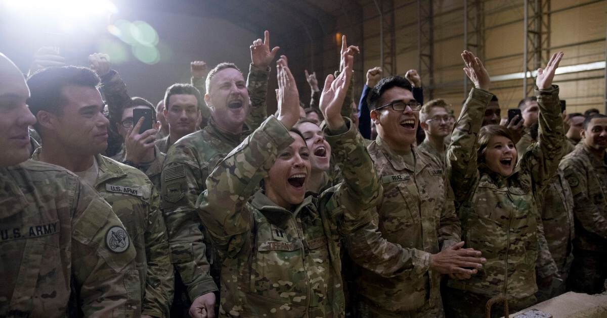 Members of the military cheer as President Donald Trump speaks at a hangar rally at Al Asad Air Base, Iraq, on Dec. 26, 2018.