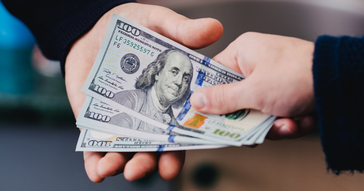 U.S. $100 bills changing hands.