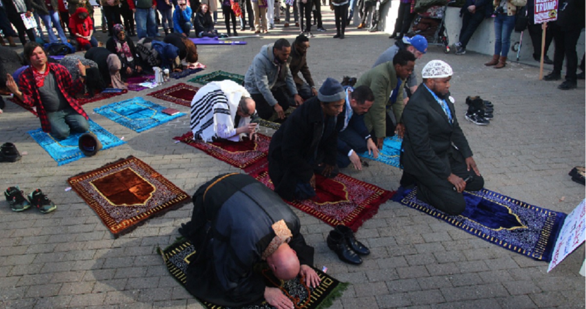 A handful of Muslims prays at noon during a Seattle protest in 2017.