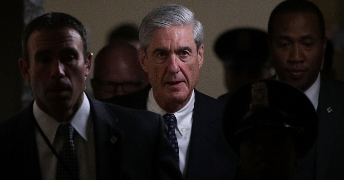 Special counsel Robert Mueller, center, leaves a meeting at the Capitol.