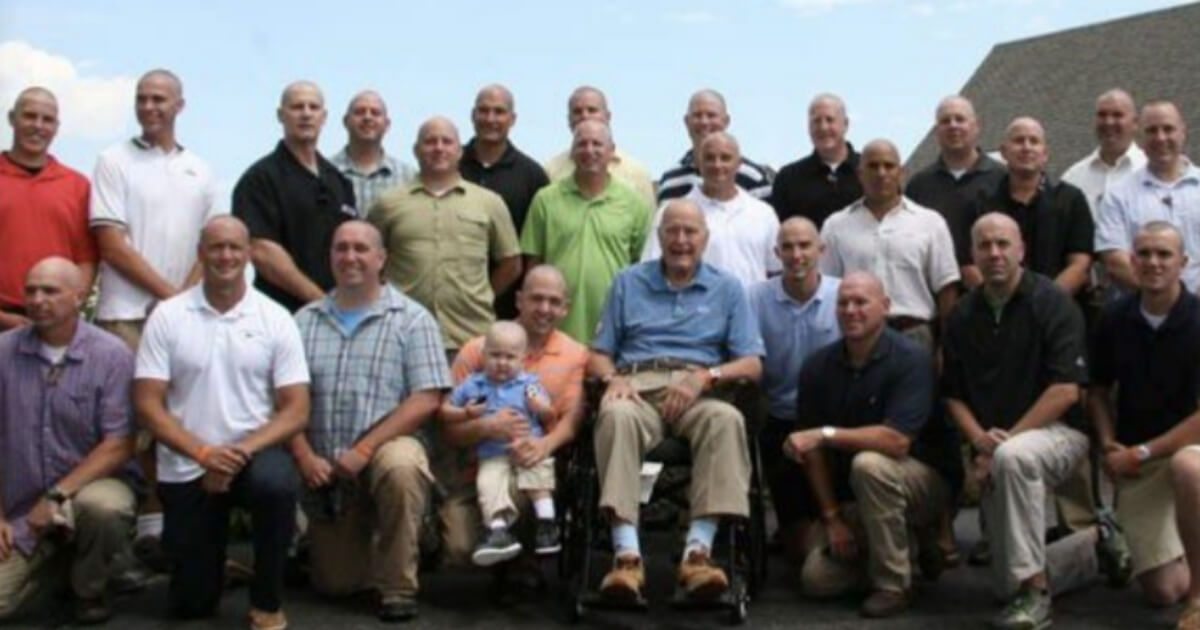 Former President George H.W. Bush (in wheelchair) joined other Secret Service agents in 2013 by shaving his head as a show of support for the 2-year-old son of an agent who was battling leukemia.