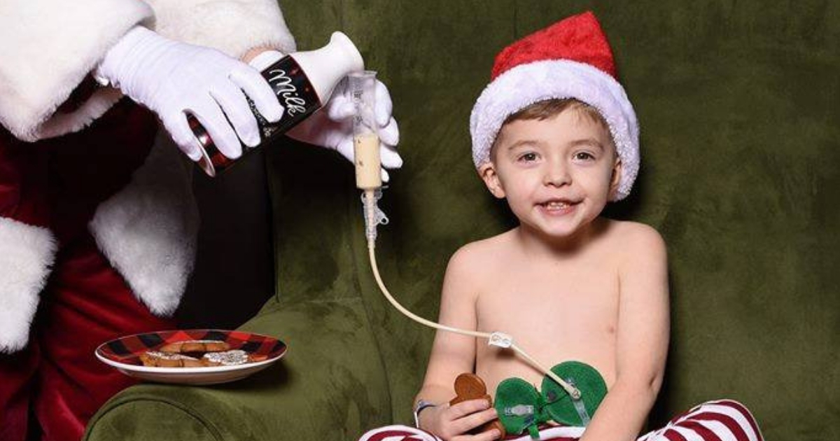 Santa shares cookies and milk with a little boy who needs a feeding tube.