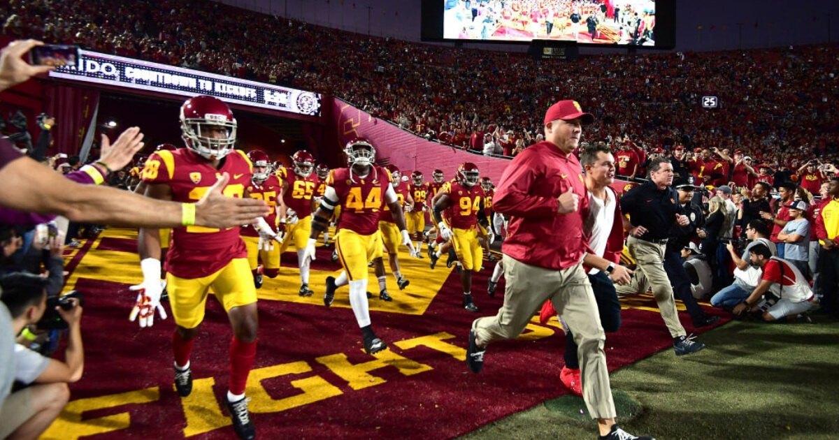 Coach Clay Helton leads the USC Trojans onto the field at the Los Angeles Memorial Coliseum.