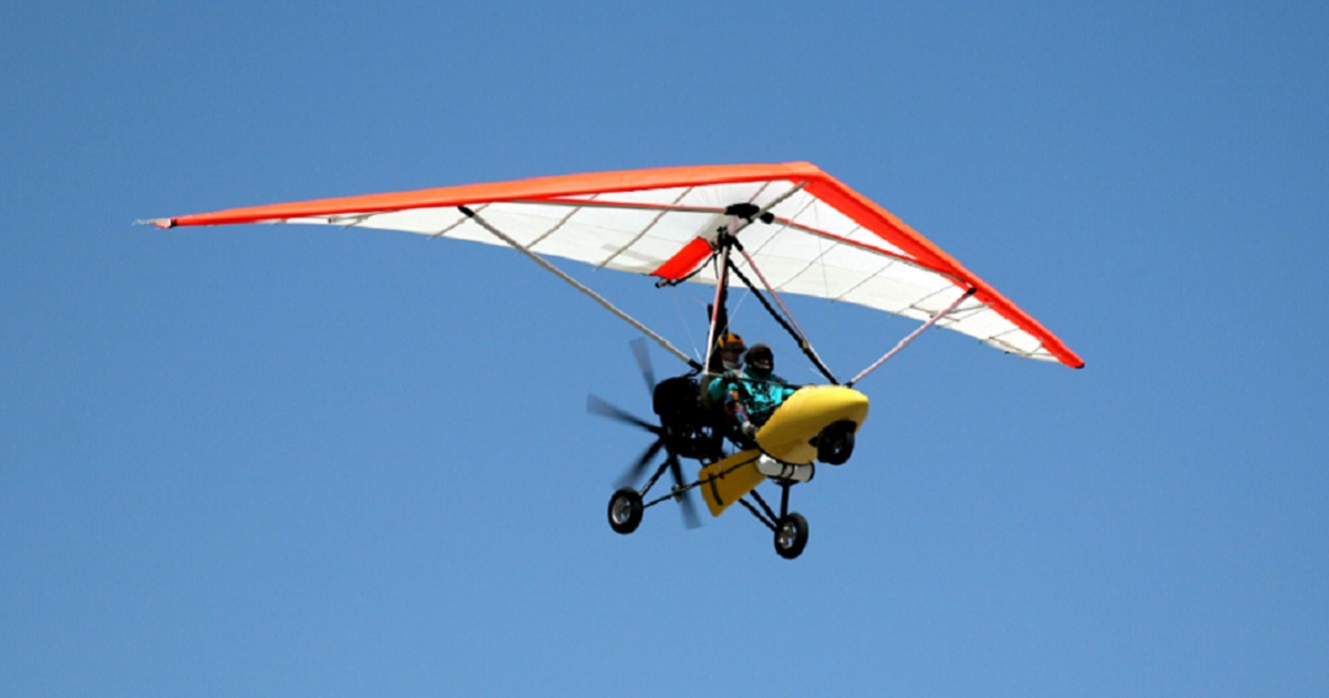 A motorized ultralight aircraft soars through a cloudless sky in a file photo.