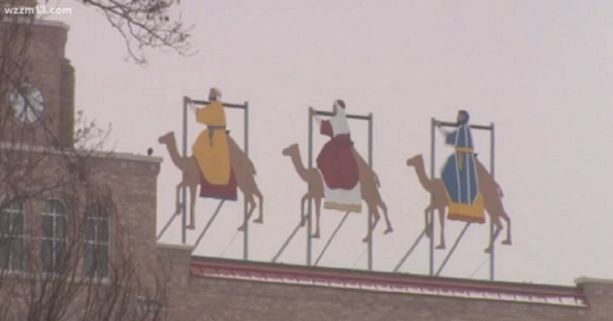 Three wise men display on a roof.