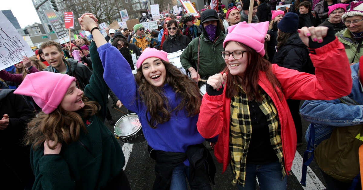 Katy Bordonaro, Dima Minkin, and Alyssa Bordonaro from Woodinville, WA march with thousands in the Women's March on Jan. 20, 2018, in Seattle, Washington.