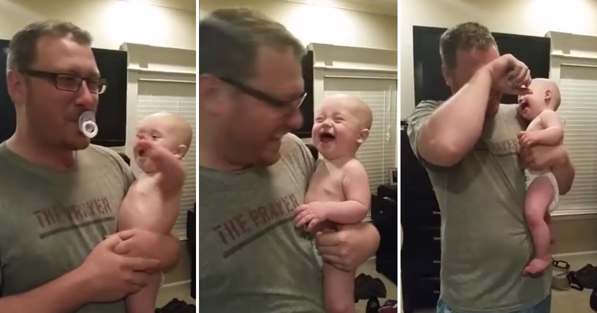 Baby giggling in dad's arms.