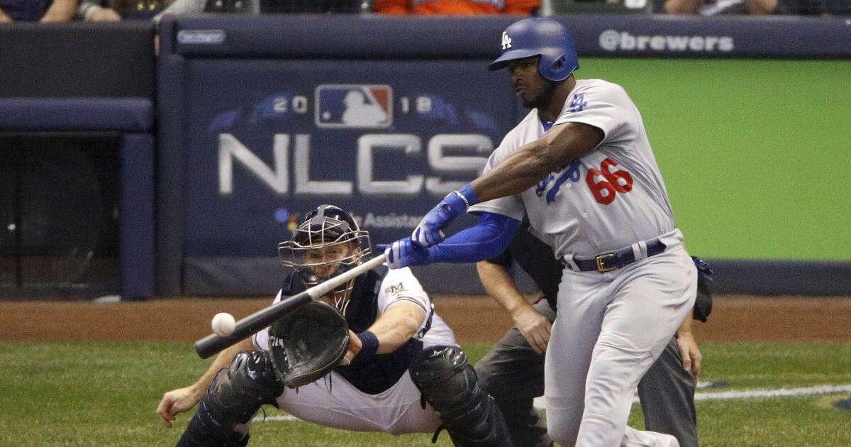 In this Oct. 20, 2018 photo, Los Angeles Dodgers outfielder Yasiel Puig hits a three -run home run during the sixth inning of Game 7 of the National League Championship Series baseball game against the Milwaukee Brewers in Milwaukee.