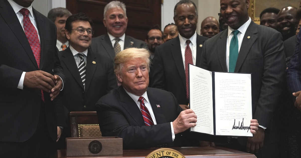 President Donald Trump participates in signing an executive order to establish the White House Opportunity and Revitalization Council as Secretary of Housing and Urban Development Secretary Ben Carson and Sen. Tim Scott look on.