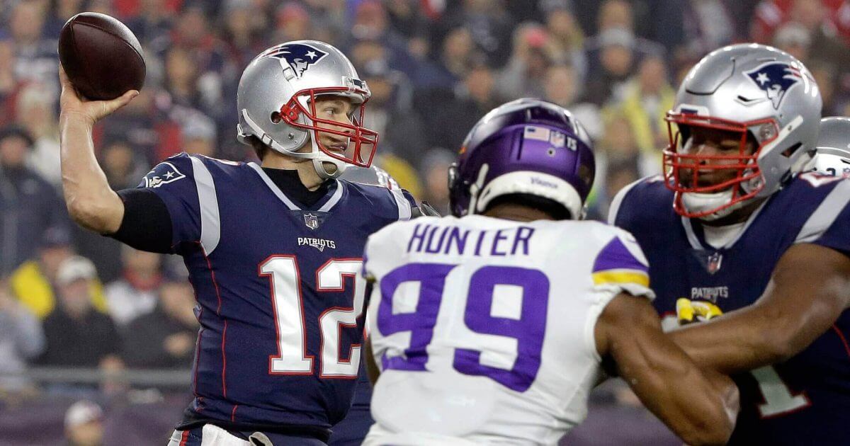 New England Patriots quarterback Tom Brady passes under pressure from Minnesota Vikings defensive end Danielle Hunter during Sunday's game at New England.