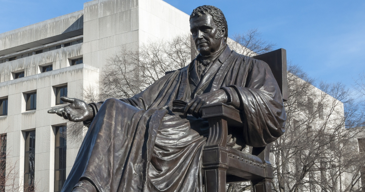 Bronze statue of John Marshall, fourth chief justice of the Supreme Court, located in John Marshall Place Park with U.S. Supreme Court building in background in Washington D.C.