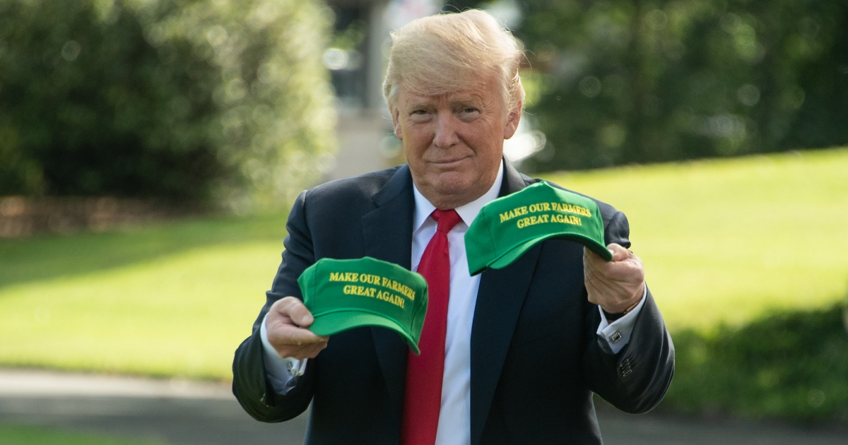 US President Donald Trump displays caps reading 'Make our Farmers Great Again'