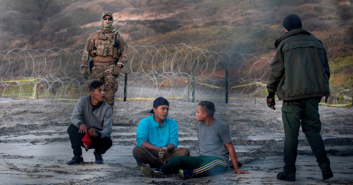 Central American migrants are taken into custody by U.S. Border Patrol agents after crossing illegally near San Diego on Dec. 13.