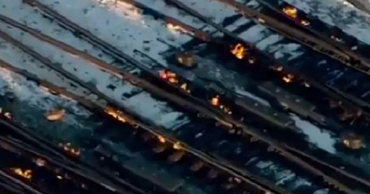 Flames visibile in aerial view of railroad tracks.