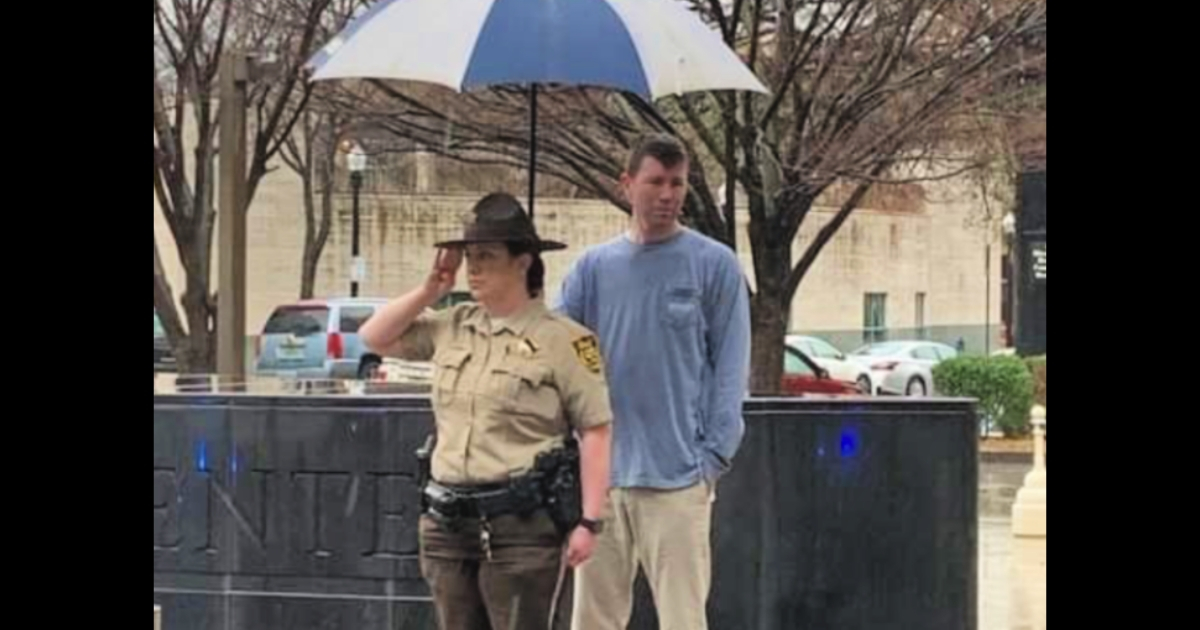 Man Holds Umbrella for Deputy