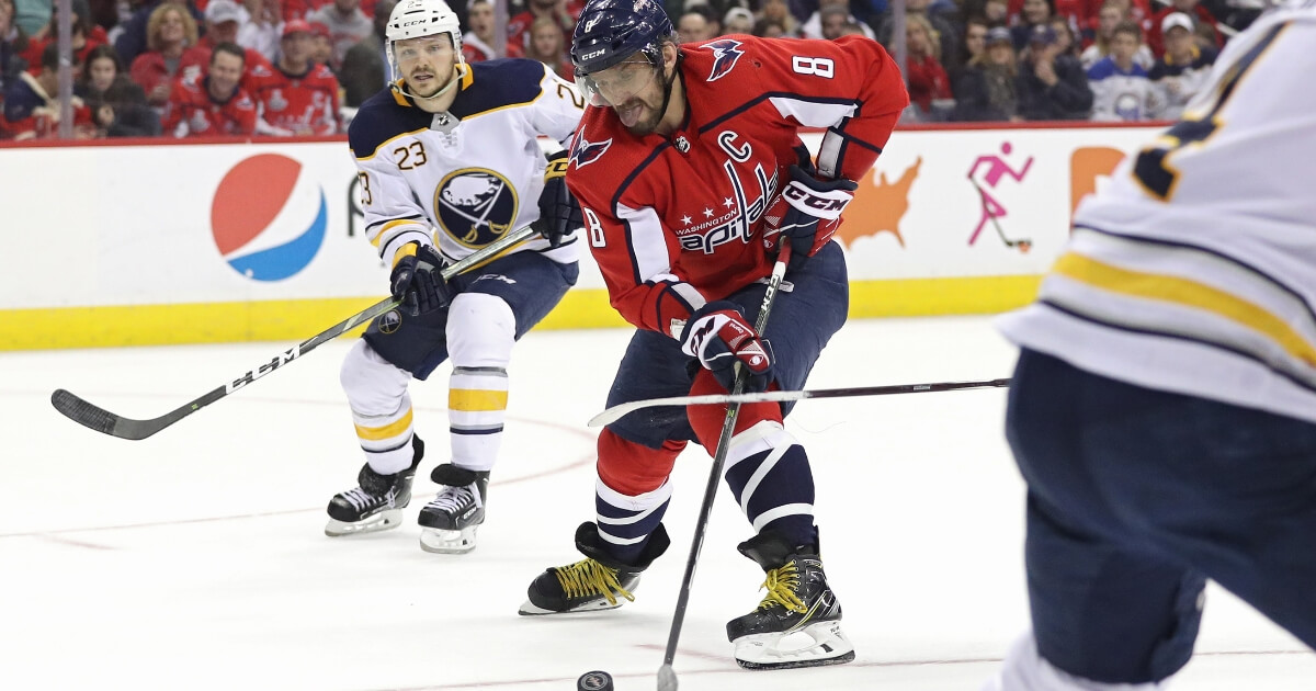 Alex Ovechkin of the Washington Capitals skates past Sam Reinhart of the Buffalo Sabres during a Dec. 15 game at Capital One Arena.