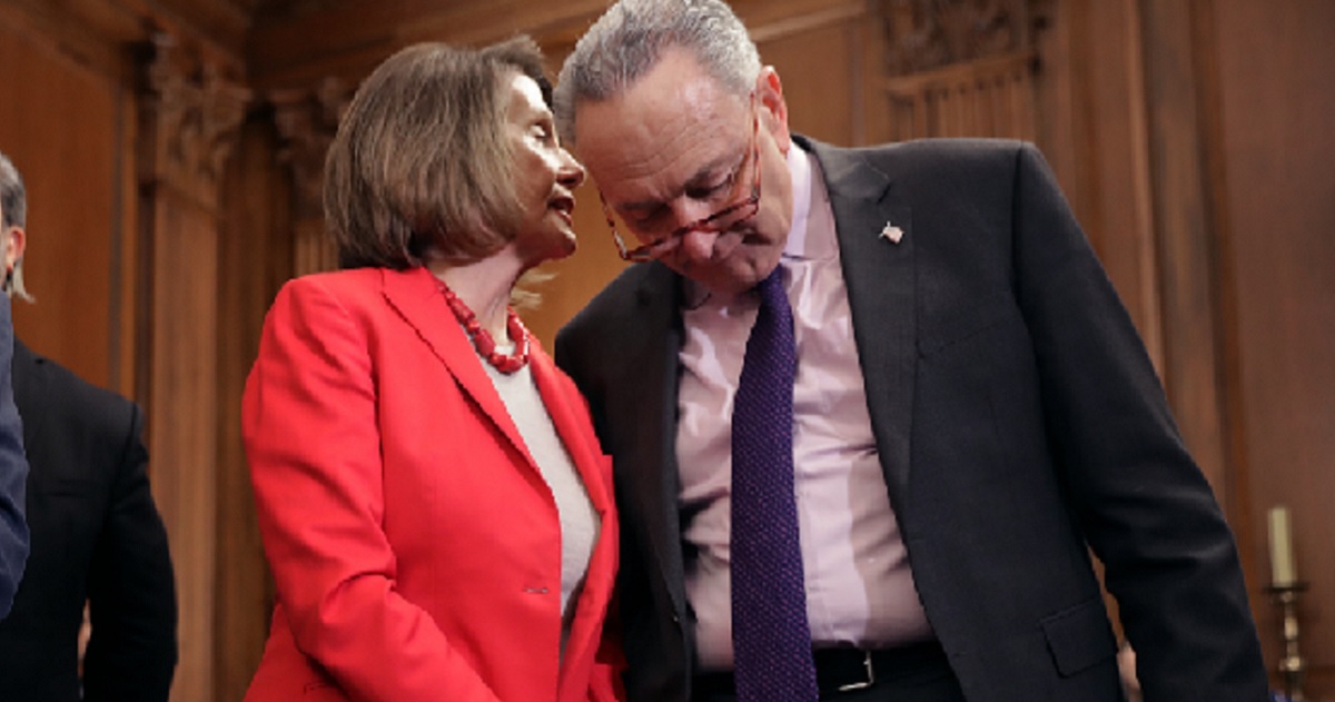 Nancy Pelosi whispering in Chuck Schumer's ear.