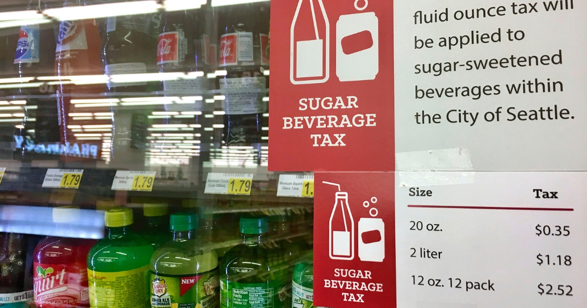 A sign posted on a drink cooler in a store gives information about a soda tax that took effect in Jan. 1, 2018, in Seattle.