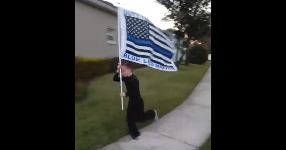 Little boy running with police flag.