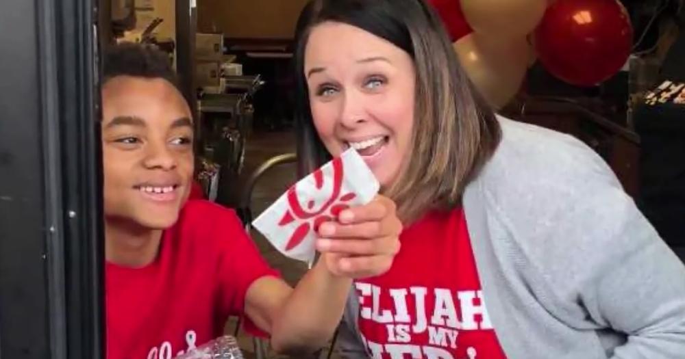 A boy passes out cookies at Chick-fil-A