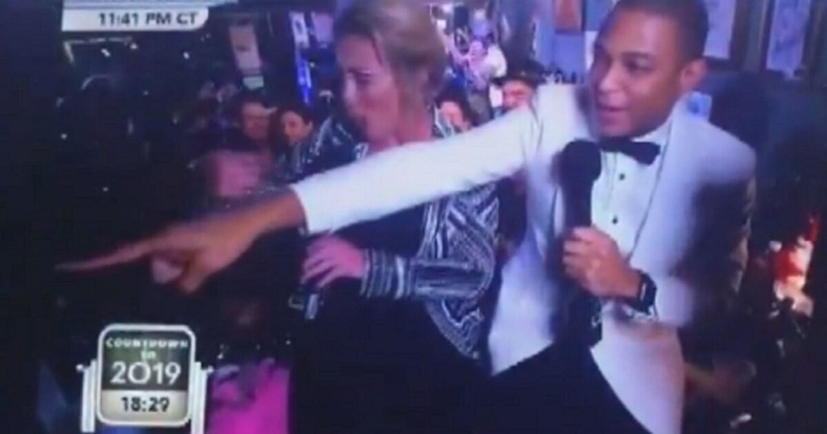 Don Lemon, in New Year's Eve attire, points into a crowd.