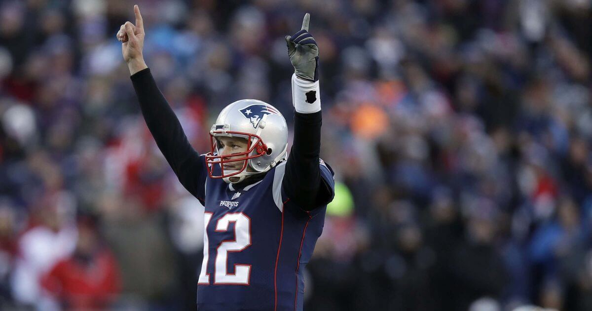 New England Patriots quarterback Tom Brady celebrates a touchdown run by running back Sony Michel during the first half of an NFL divisional playoff football game against the Los Angeles Chargers on Sunday in Foxborough, Mass.