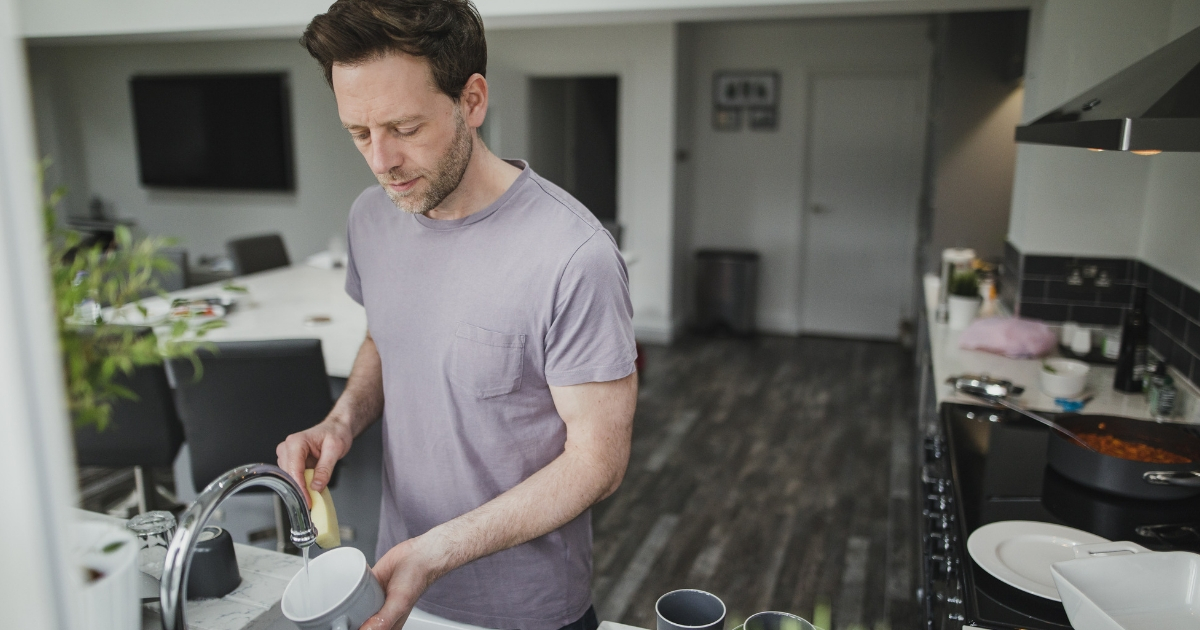 Man washing dishes in the kitchen.