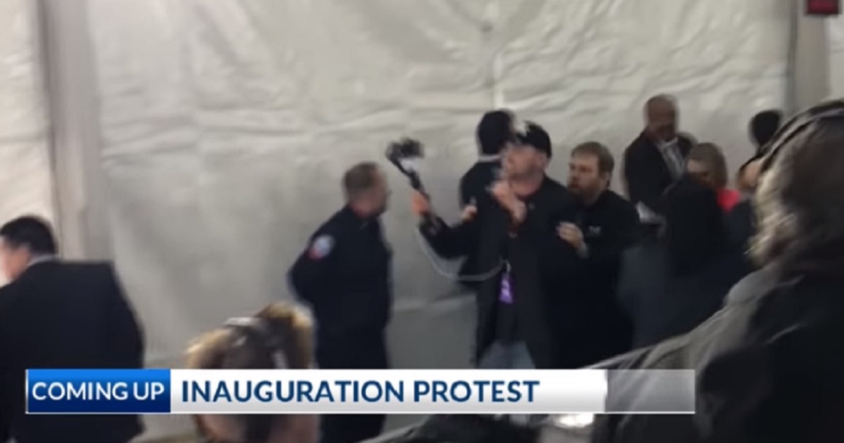 Conservative political activist Ben Bergquam is escorted out of the swearing-in ceremony for California Gov. Gavin Newsom on Monday after loudly protesting Democratic policies on illegal immigration.