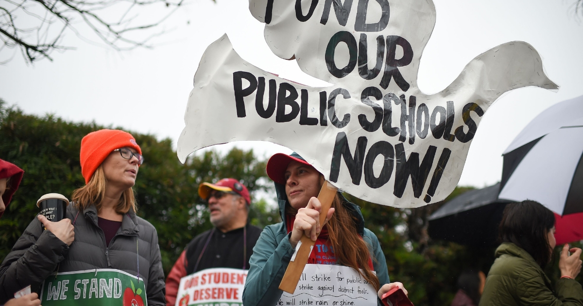 Striking teachers are joined by parents and students on the picket line outside Dahlia Heights Elementary School in the Eagle Rock section of Los Angeles, California.
