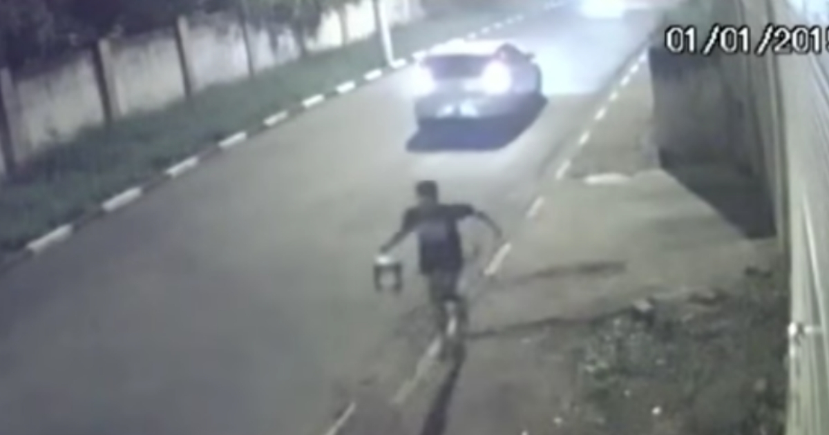 Man running from robbers in a car.