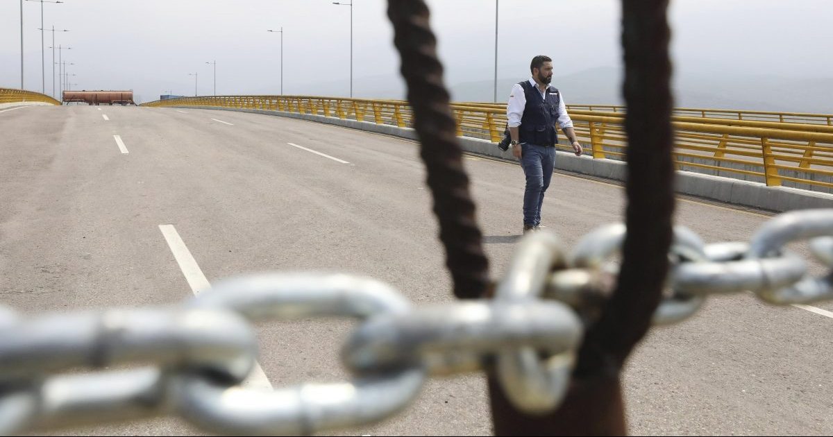 An immigration official walks on the Tienditas International Bridge after Venezuelan authorities used a fuel tanker, cargo trailers and makeshift fencing in an attempt to block humanitarian aid entering from Colombia as seen from the outskirts of Cucuta, Colombia.