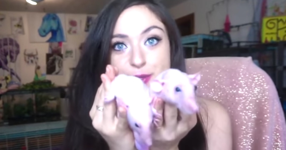 Woman holds two rats.