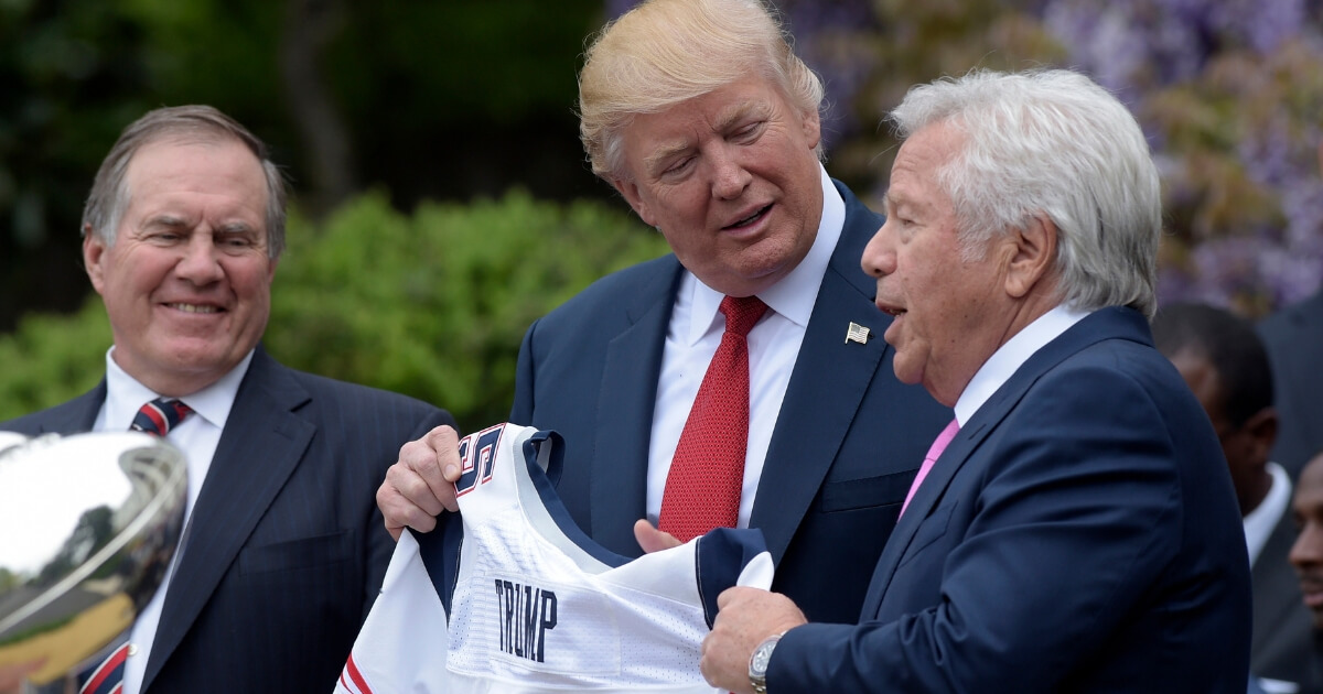 President Donald Trump is presented with a New England Patriots jersey from Patriots owner Robert Kraft, right, and head coach Bill Belichick during a ceremony on the South Lawn of the White House in Washington on April 19, 2017.