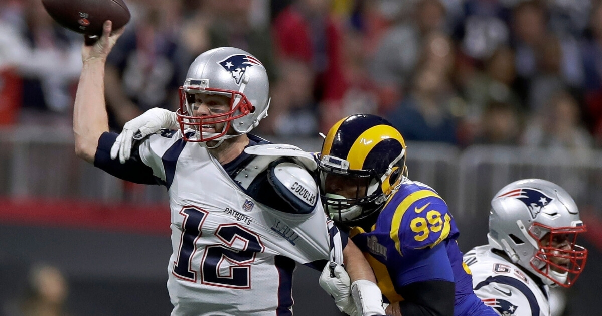New England Patriots' Tom Brady passes under pressure from the Los Angeles Rams' Aaron Donald during the first half of Super Bowl LIII Sunday in Atlanta.
