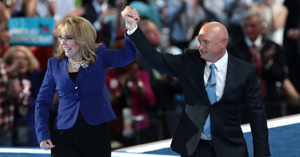 Former Congresswoman Gabby Giffords and her husband, retired NASA Astronaut and Navy Captain Mark Kelly, hold hands as they walk off stage after delivering remarks on the third day of the Democratic National Convention at the Wells Fargo Center, July 27, 2016.