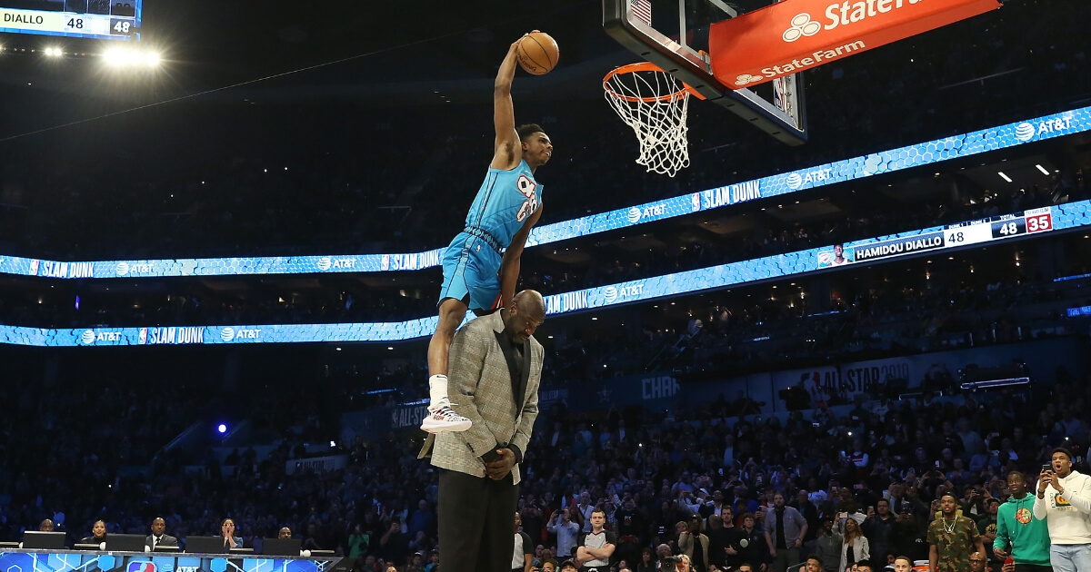 Hamidou Diallo #6 of the Oklahoma City Thunder dunks over Shaquille O'Neal during the AT&T Slam Dunk as part of the 2019 NBA All-Star Weekend at Spectrum Center on February 16, 2019 in Charlotte, North Carolina