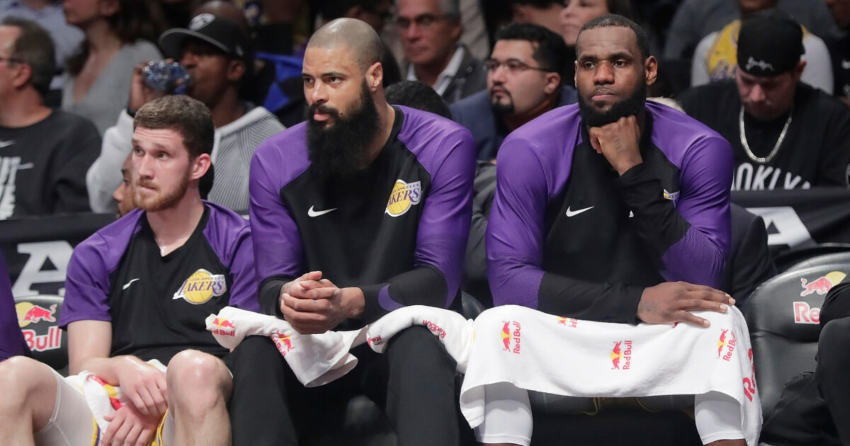 The Los Angeles Lakers' LeBron James, right, and Tyson Chandler, center, watch their team play against the Brooklyn Nets on Dec. 18, 2018, in New York.