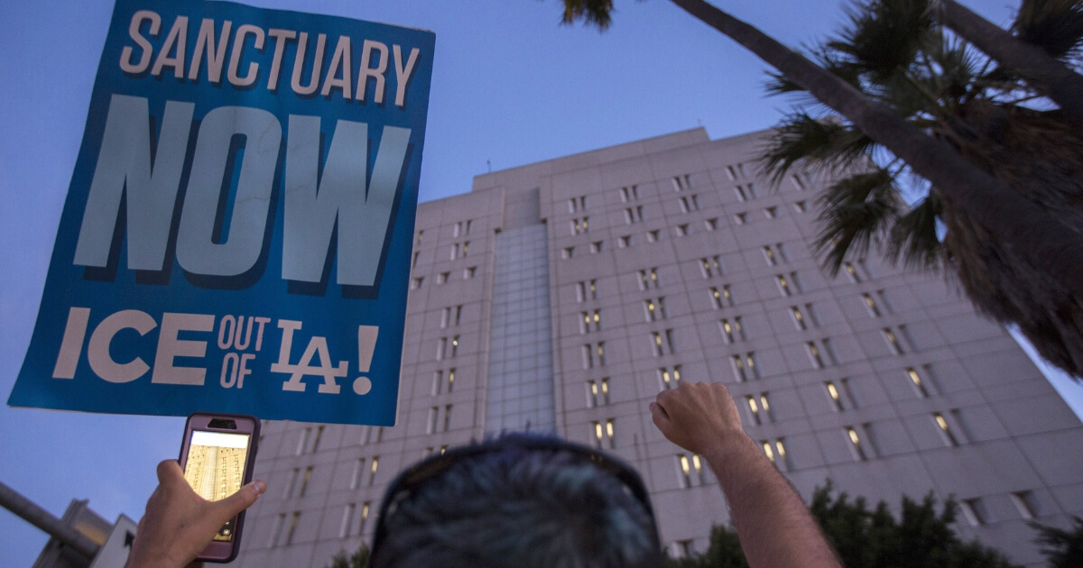 A pro-sanctuary city sign is held up during a protest outside the Metropolitan Detention Center in Los Angeles on June 14, 2018.