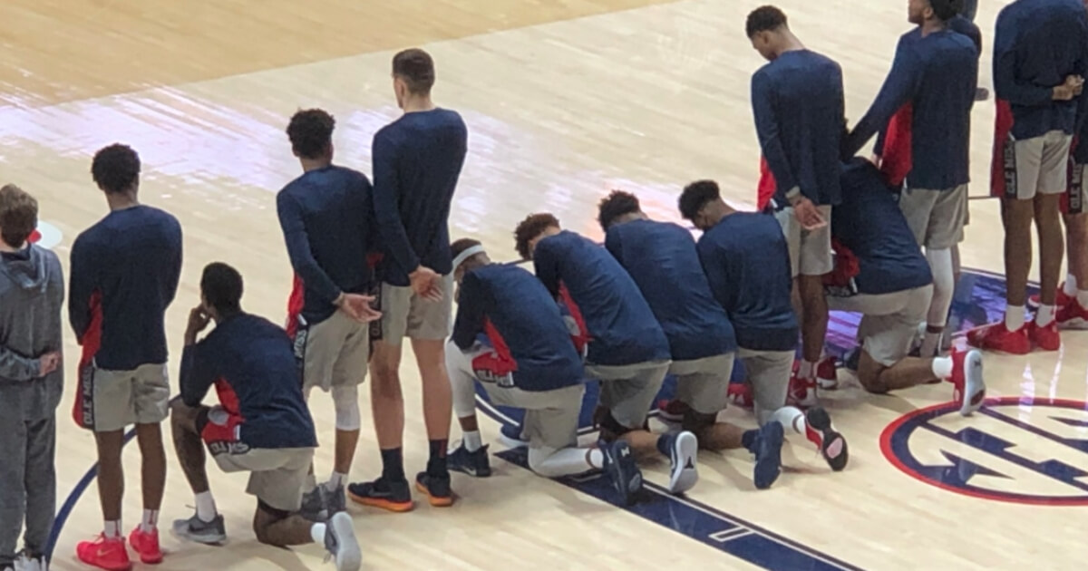 Members of the Ole Miss basketball team kneel in protest during the national anthem.