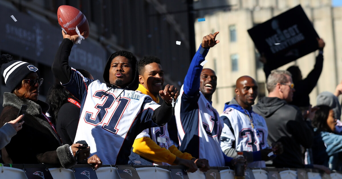 The New England Patriots ride down Cambridge Street during in Boston during their championship parade Tuesday.