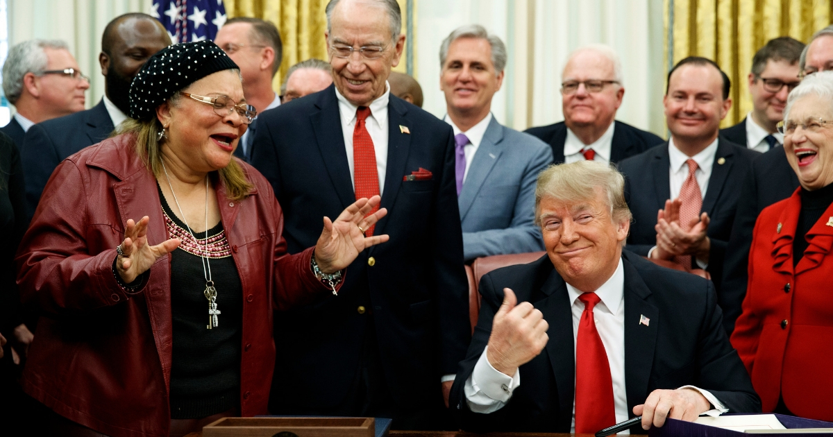 President Donald Trump reacts as Alveda King, niece of Rev. Martin Luther King Jr., speaks during a signing ceremony for criminal justice reform.