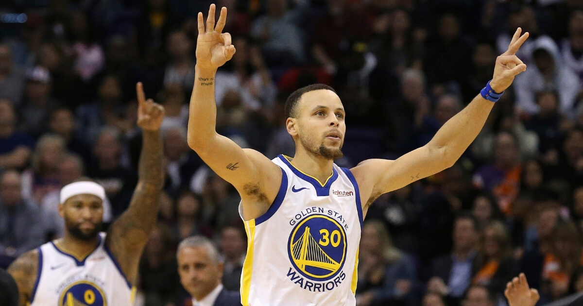 Golden State Warriors guard Stephen Curry celebrates his 3-pointer against the Phoenix Suns along with Warriors center DeMarcus Cousins on Friday.